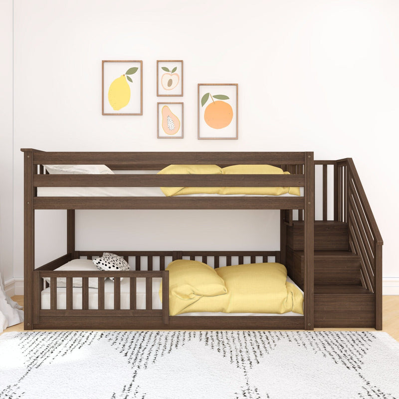 Modern wooden bunk bed with yellow cushions and staircase, decorated with fruit wall art in a bright kids' room.