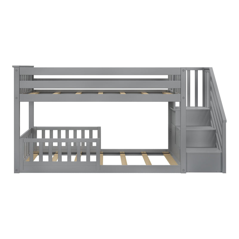 Gray twin-over-twin bunk bed with stairs and safety rails for kids' bedroom.