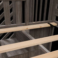Close-up of light pine wooden slats and metal support beam against dark gray weathered wood panels showing wood grain texture and rustic construction details