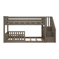 Twin-over-full bunk bed with staircase storage, gray-brown wood finish, slatted guardrails and space-saving design for children’s bedroom