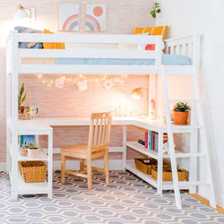 White loft bed with built-in L-shaped desk and shelves, wooden ladder and chair, pink patterned wallpaper, string lights, potted plant and storage baskets — kids' study nook