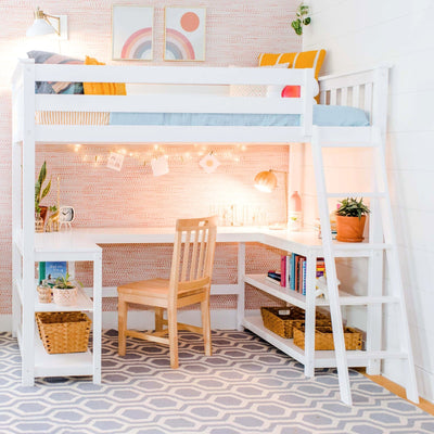 Kids loft bed with built-in L-shaped study desk and ladder in pastel pink bedroom, wooden chair, string lights, potted plants, bookshelf and woven baskets on gray geometric rug