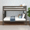 Gray wooden twin-over-twin bunk bed with white bedding, blue throw and decorative pillows against patterned blue wallpaper in a modern kids' bedroom