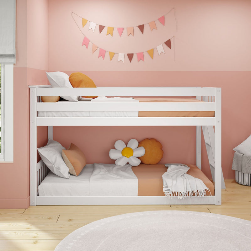 White bunk bed in a cozy pink children's room with decorative pillows and colorful flag garland.