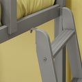 Close-up of gray folding step ladder mounted on yellow wall showing hinge, bolts and slatted step treads
