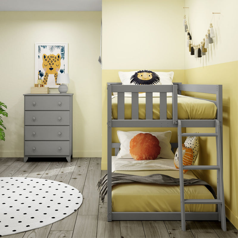 Kids' bedroom nursery decor with gray bunk bed, yellow bedding, lion face pillow, gray dresser, framed animal print, tassel wall garland and polka-dot rug