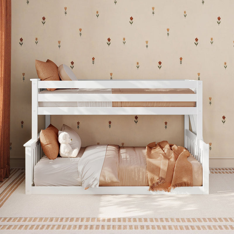 White wooden bunk bed in a neutral kids bedroom with beige floral wallpaper, tan bedding, rust-colored throw blanket, pillows and a plush teddy bear