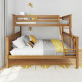 Modern wooden twin-over-full bunk bed with ladder, gray knit bedding and yellow accent pillows, brass wall sconces and neutral curtains in a bright kids' bedroom