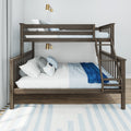 Dark wood twin-over-full bunk bed with ladder, blue and white bedding and pillows, brass wall sconces and light grey curtains in a modern kids bedroom