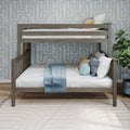 Gray wood twin-over-twin bunk bed with white and blue bedding, decorative pillows and blue geometric wallpaper in a modern kids bedroom