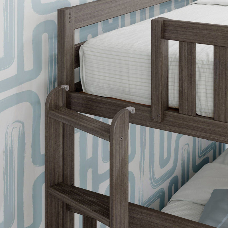 Dark wood bunk bed with ladder and white bedding against modern geometric wallpaper.