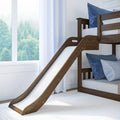 Dark walnut wooden bunk bed with built-in white slide in bright kids' bedroom with blue pillows and large window view