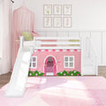 White wooden kids loft bed with slide and stairs featuring a pink playhouse curtain, pastel pillows and floral wall art, ideal girls' bedroom decor