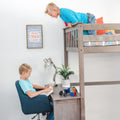 Wooden loft bed with built-in desk in modern boys' bedroom — one boy reading at desk with toy car and Rubik's Cube, another leaning from top bunk under a framed "Mini Man Cave" sign