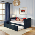 Kids bedroom with navy blue daybed and pull-out trundle, striped blue wallpaper, navy curtains, red accent pillows, wicker pendant light and framed red vintage SUV art
