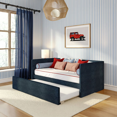 Modern nautical children's bedroom with navy daybed and pull-out trundle, blue-striped wallpaper, navy sheer curtains, red accent pillows and framed red jeep art