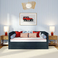 Blue striped wallpaper bedroom with navy upholstered daybed, red and blush accent pillows, framed vintage red jeep print, wooden nightstands, table lamps and woven rattan pendant light
