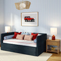 Kids bedroom with navy daybed, red and blue pillows, blue-and-white striped wallpaper, framed vintage red jeep print, wooden nightstand with alarm clock and toy airplane, rattan pendant light
