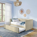 Modern light-blue bedroom with neutral upholstered trundle bed, geometric rug, sheer curtains and boho rattan wall decor