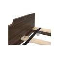 Dark walnut headboard and wooden bed slats with black metal center rail and caster wheel – bed frame assembly detail