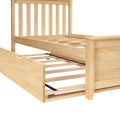 Pine wood platform bed frame with slatted headboard and pull-out trundle drawer in light natural finish — space-saving storage bed for kids or guest rooms