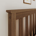 Close-up of a dark brown stained solid wood slatted bed headboard with vertical slats and visible wood grain, modern bedroom decor