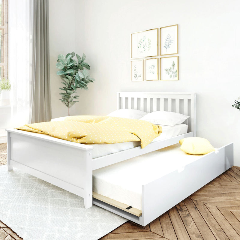 White wooden bed with pull-out trundle and yellow polka-dot duvet in a minimalist bedroom with botanical wall art, fiddle-leaf plant and natural light