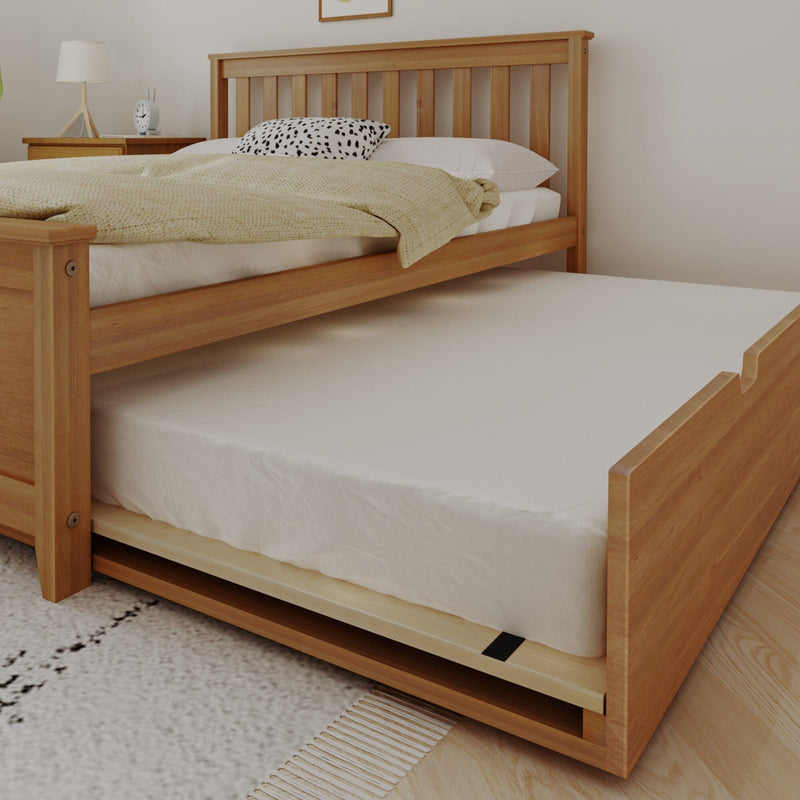 Solid wood trundle bed with slatted headboard and pull-out mattress, neutral bedding and bedside table in modern Scandinavian bedroom