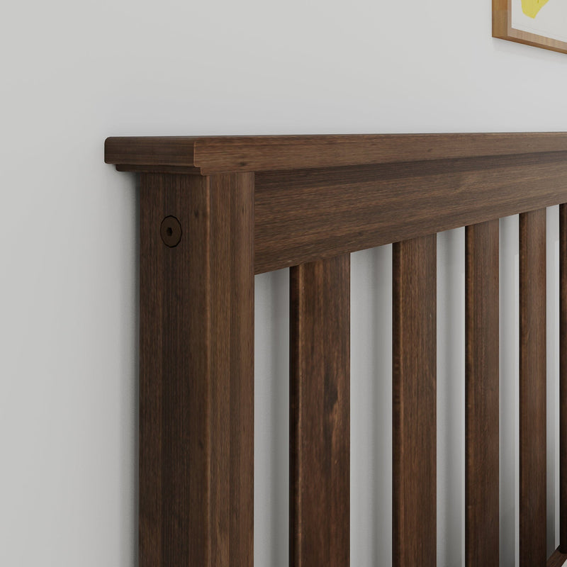 Dark walnut slatted headboard close-up against white wall, modern wooden bedroom furniture detail