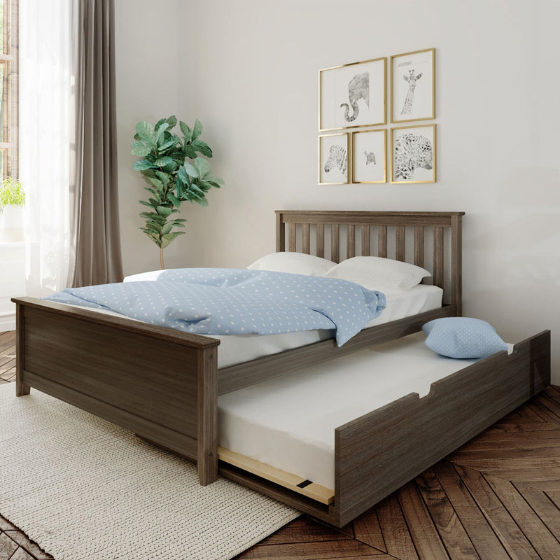 Wooden bed frame with a trundle mattress and blue polka dot bedding in a modern bedroom.