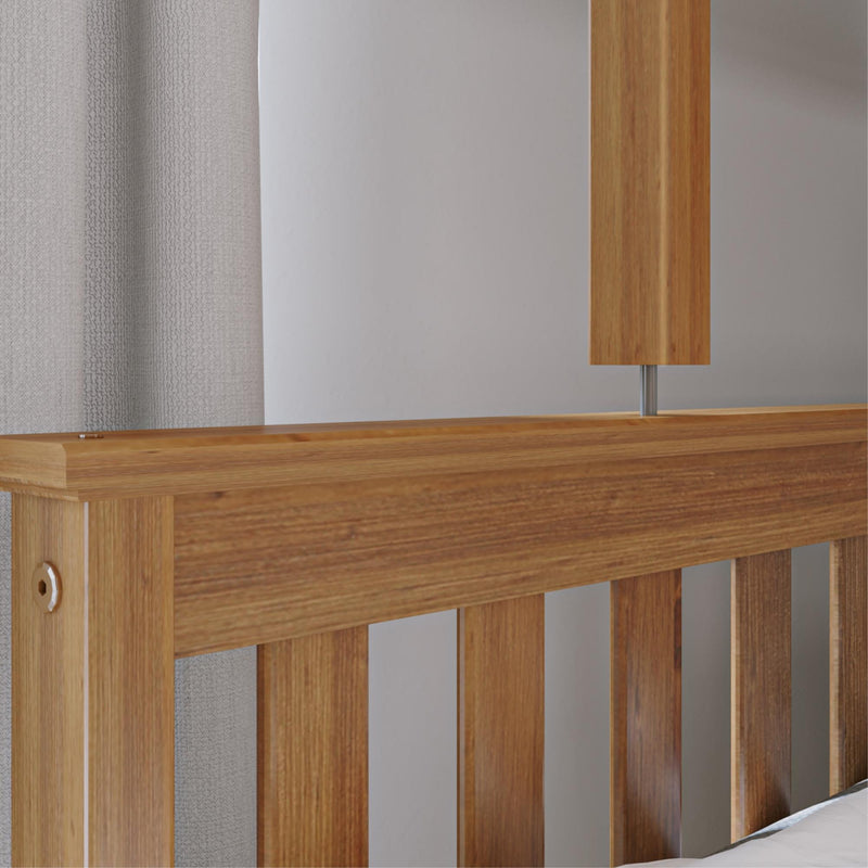Close-up of a wooden bed frame with modern design elements and a neutral gray curtain background.