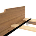 Close-up of walnut wood platform bed frame headboard and wooden slats with caster wheel and assembly hardware