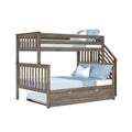 Rustic gray wood twin-over-full bunk bed with pull-out trundle, built-in staircase and safety rails, styled with light blue sheets and pillows for a kids' bedroom
