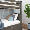 Gray wood twin-over-twin bunk bed in kids bedroom with white bedding, blue striped and tan throw pillows, knitted round blue cushion, geometric blue wallpaper, fiddle leaf fig plant and hardwood floor