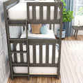 Grey wooden twin-over-twin bunk bed with ladder in a modern kids' bedroom, white striped bedding, decorative throw pillows, blue curtains and potted plant