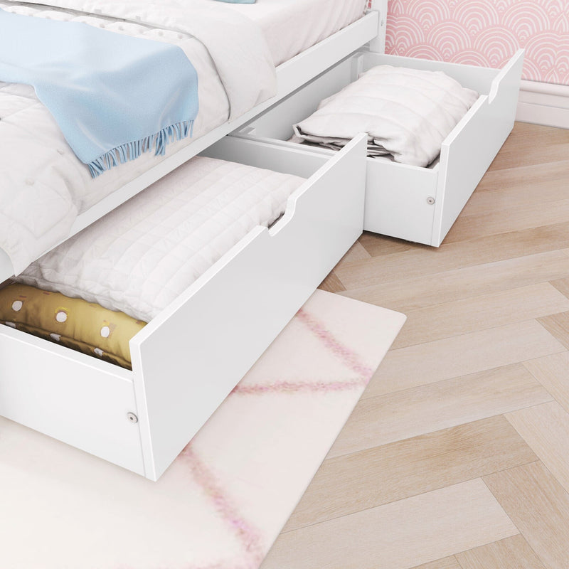 White platform bed with two pull-out underbed storage drawers holding quilts and pillows in a light pink children's bedroom — space-saving under-bed storage solution for small rooms