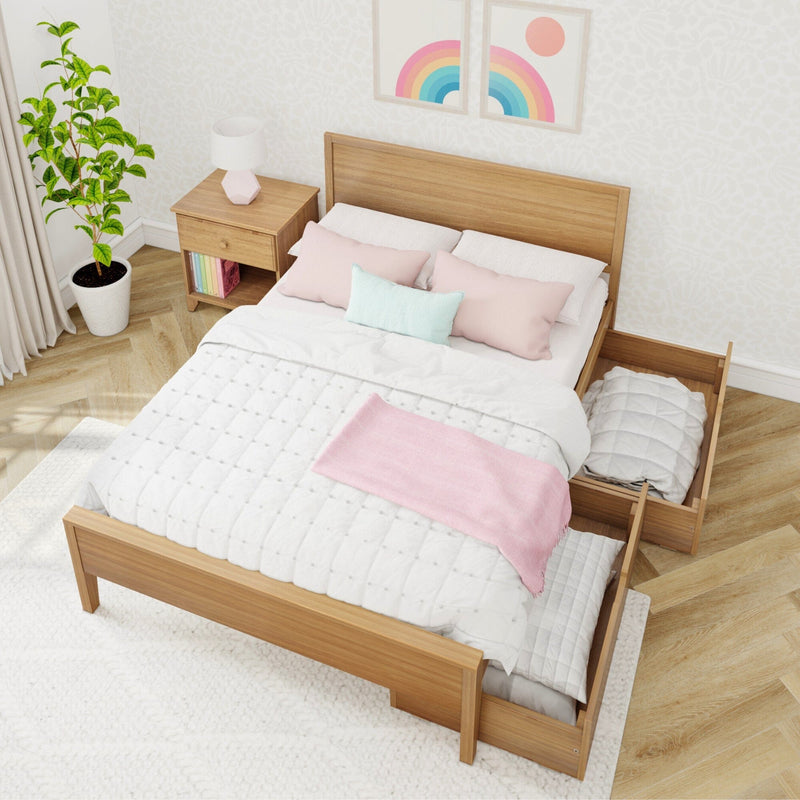 Modern bedroom with wooden bed featuring built-in storage drawers, cozy pink and blue pillows, white bedding, and adjacent nightstand with a colorful rainbow print on the wall.