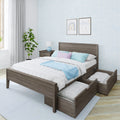 Modern gray wood platform bed with built-in under-bed storage drawers, pastel blue and lavender bedding, nightstand with lamp, potted plant and light blue patterned wallpaper in a bright bedroom