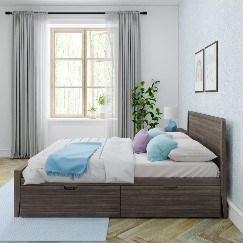 Modern bedroom with a wooden bed featuring drawers, colorful pillows, a large window, and a decorative plant.