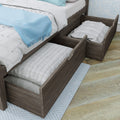 Wooden platform bed with under-bed pull-out storage drawers and white quilted bedding, light blue throw blanket on hardwood bedroom floor