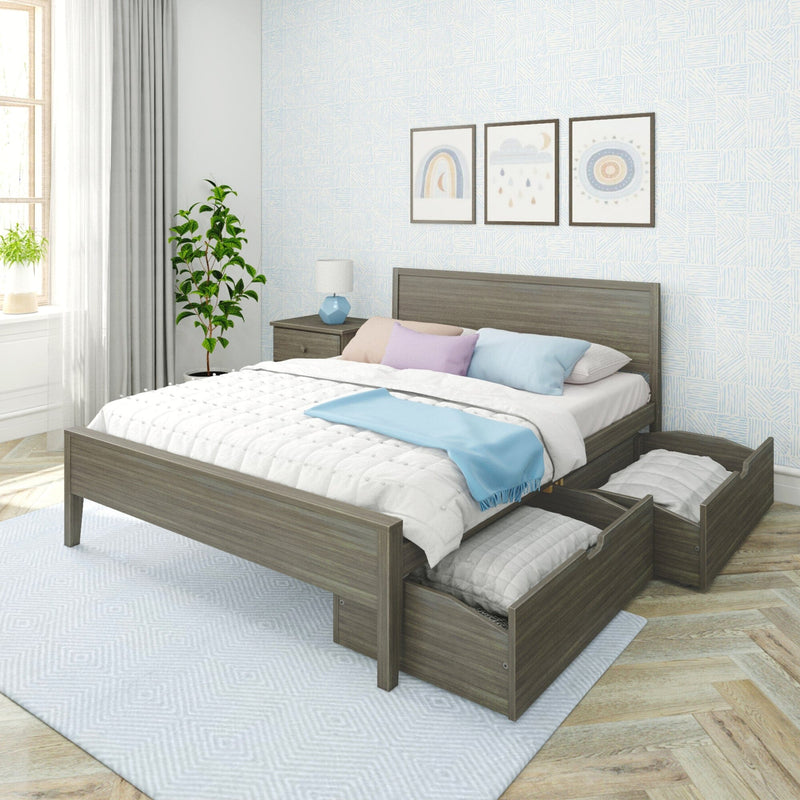 Modern grey wood queen storage platform bed with two under-bed pull-out drawers, white quilted bedding, pastel pillows and a blue throw in a bright Scandinavian-style bedroom with nightstand, lamp, framed wall art and potted plant
