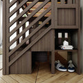 Modern dark wood diagonal-slatted staircase with built-in under-stair storage cubbies holding navy sneakers and stacked magazines on parquet floor