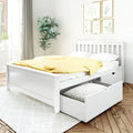 White wooden platform storage bed with slatted headboard and pull-out drawer, dressed in yellow polka-dot duvet and white pillows in a bright modern farmhouse bedroom