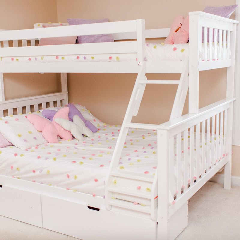 White wooden bunk bed with ladder in a pastel children's bedroom, featuring white pom-pom bedding, pink and purple star-shaped pillows and under-bed storage drawers