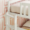 White wooden bunk bed ladder and safety guardrail against blush pink retro wallpaper with beige bedding — modern space-saving kids' bedroom design