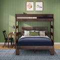 Dark walnut wooden bunk bed with navy bedding and plaid pillows against sage green paneled wall, small desk with lamp and sports wall art, kids' bedroom interior