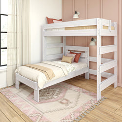 Whitewashed wooden twin-over-twin bunk bed with ladder in pastel pink kids’ bedroom, neutral bedding, decorative pillows and boho area rug
