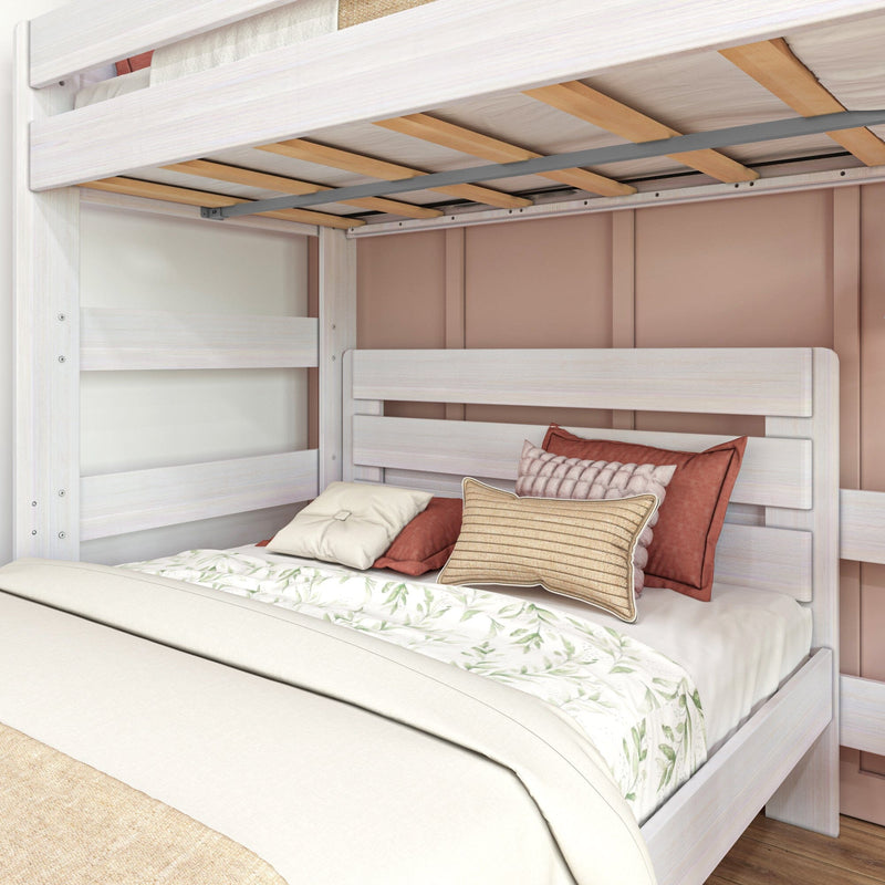 White wooden bunk bed with lower full bed, floral duvet cover and textured throw pillows against a blush-pink paneled wall in a modern farmhouse bedroom