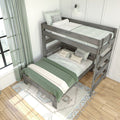 Space-saving twin-over-full rustic gray wooden bunk bed with green and white bedding, patterned rug, ladder and natural light from window in a bright modern farmhouse bedroom