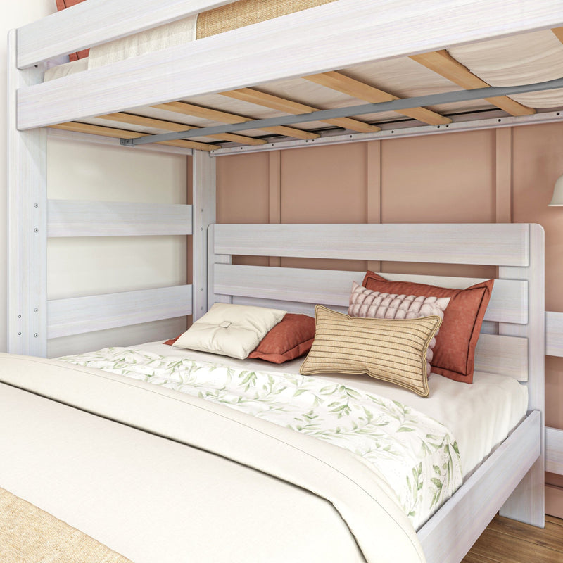 Whitewashed wooden bunk bed with full-size lower bed, neutral floral duvet and layered decorative throw pillows in a cozy modern bedroom